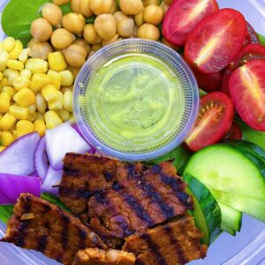 Vegan Cobb Salad with avocado lime dressing, spinach, cucumbers, chick peas, corn, and onions.