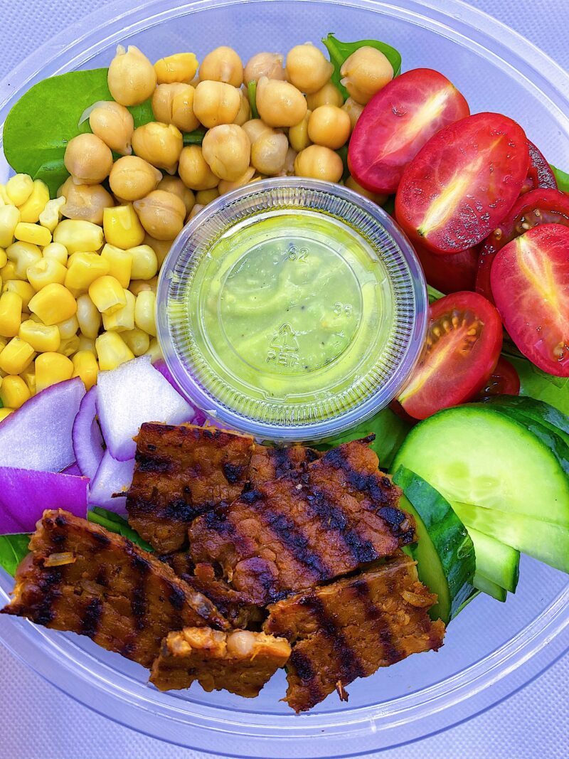 Vegan Cobb Salad with avocado lime dressing, spinach, cucumbers, chick peas, corn, and onions.