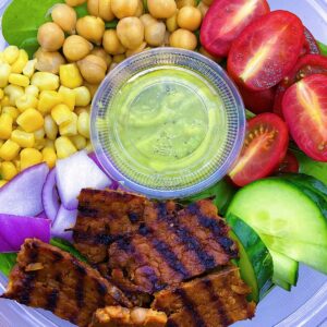 Vegan Cobb Salad with avocado lime dressing, spinach, cucumbers, chick peas, corn, and onions.