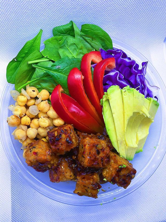 Orange Ginger Tempeh Bowl Made with multigrain rice, spinach, purple cabbage, chick peas, and sweet red bell peppers