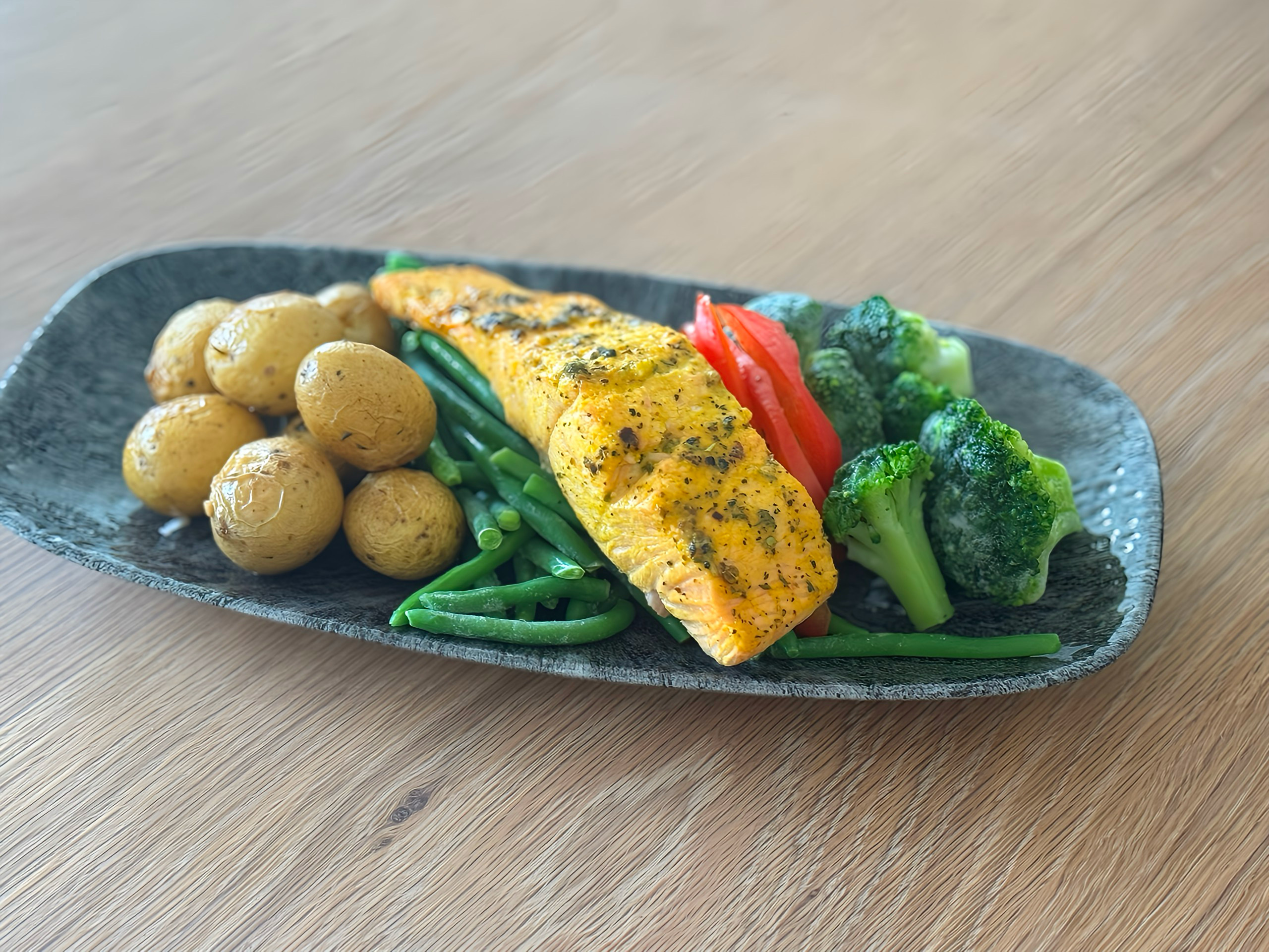 Lemon Pepper Salmon served with a side of basmati rice, broccoli, bell peppers, and a side of tartar sauce