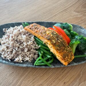 Baked Cajun Salmon served with a side of multigrain rice, sweet broccolini, and sweet bell peppers