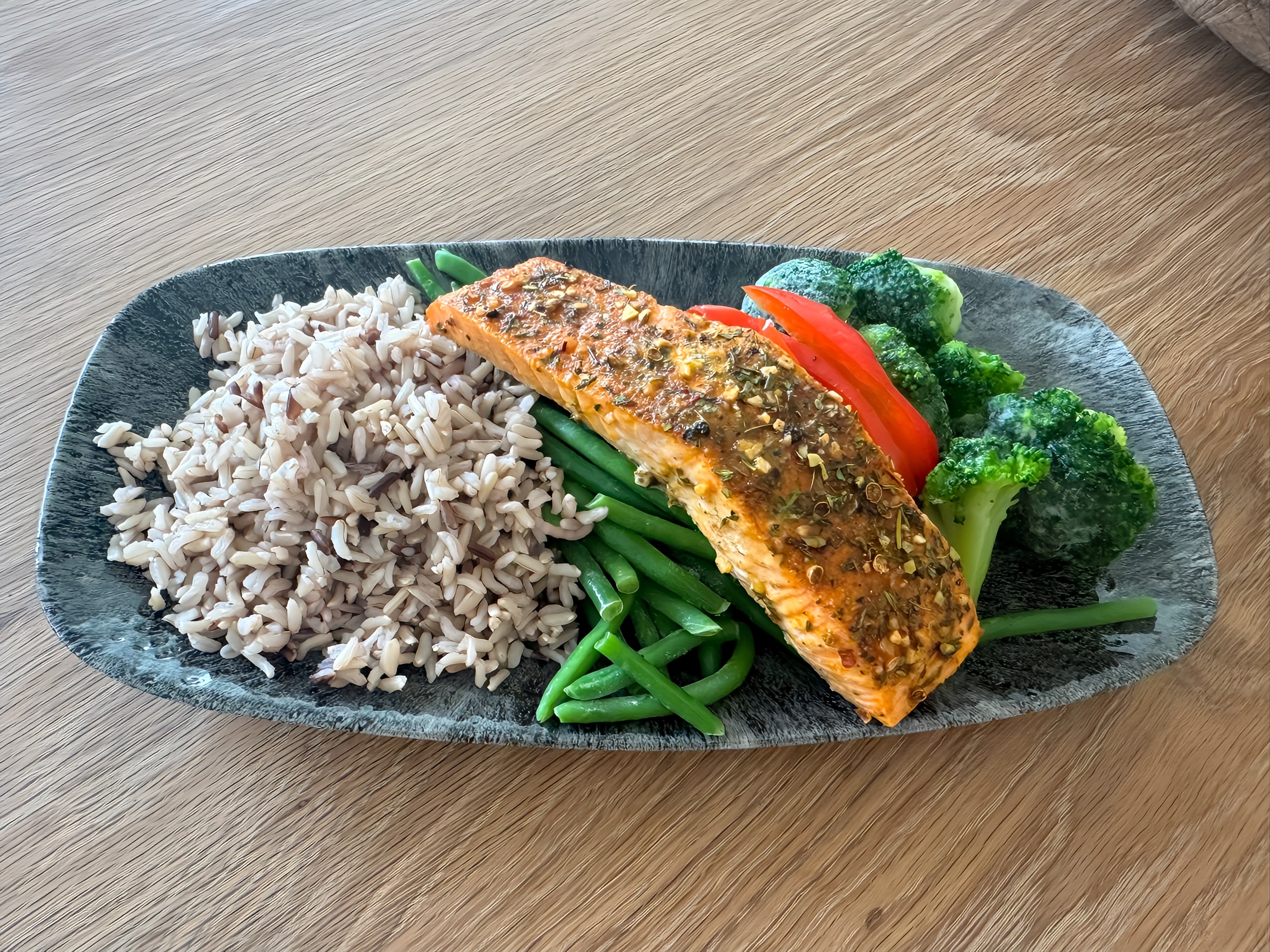 Baked Cajun Salmon served with a side of multigrain rice, sweet broccolini, and sweet bell peppers