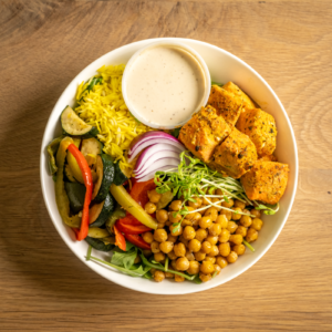 Garlic and herb grilled salmon served with turmeric rice, roasted chickpeas, and mixed roasted veggies with a side of housemade tahini sauce